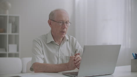 Ein-älterer-Mann-Nutzt-Die-Online-Konsultation-Mit-Einem-Spezialisten-Per-Laptop-Mit-Internet,-Bleibt-Zu-Hause-Und-Ruft-Per-Video-An